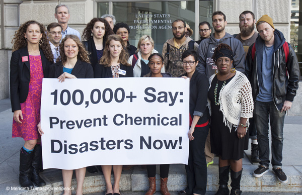 Group of people holding sign saying 100,000+ Say: Prevent Chemical Disasters Now