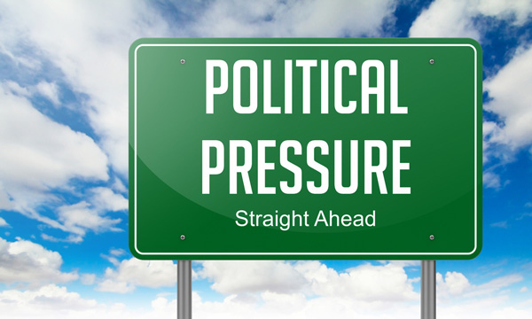 Road sign reading "political pressure straight ahead"