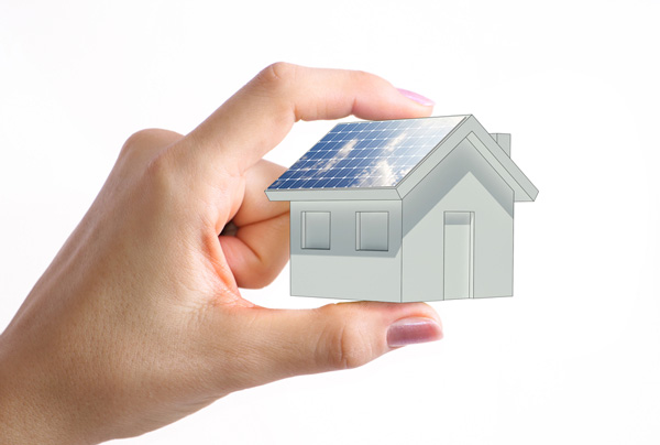 Hand holding tiny solar house