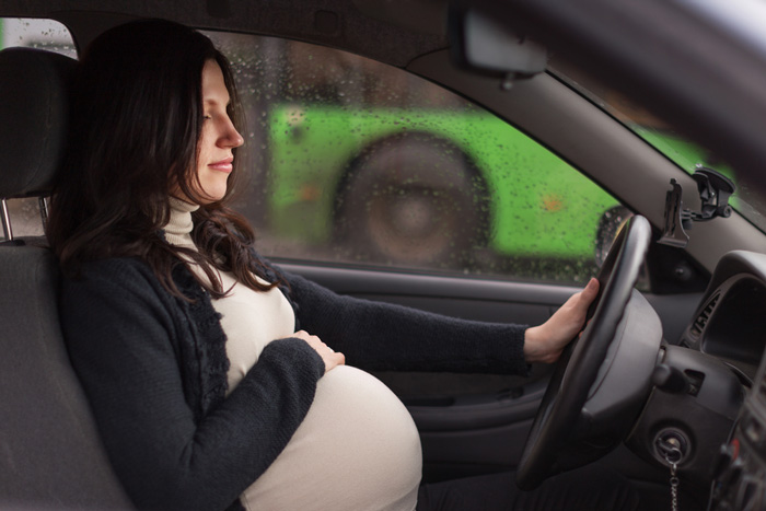 Pregnant woman sitting in car