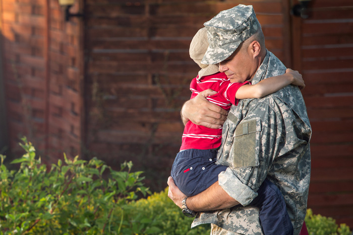 Military dad hugging his child