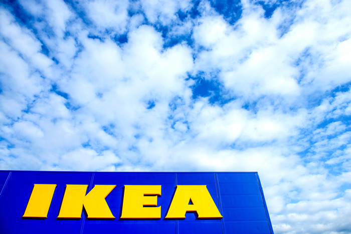 IKEA sign against blue sky with white clouds backdrop