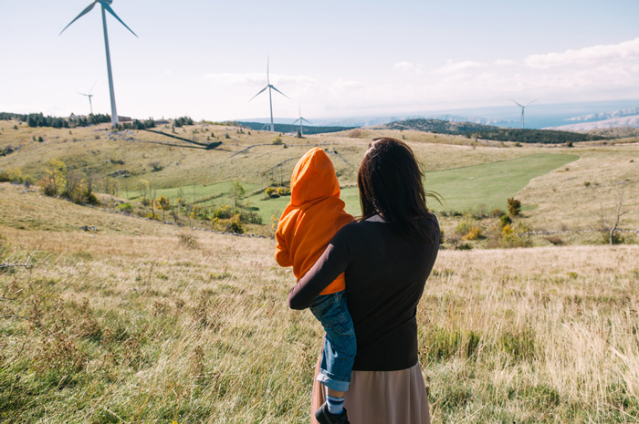 Mother and child watching wind turbines