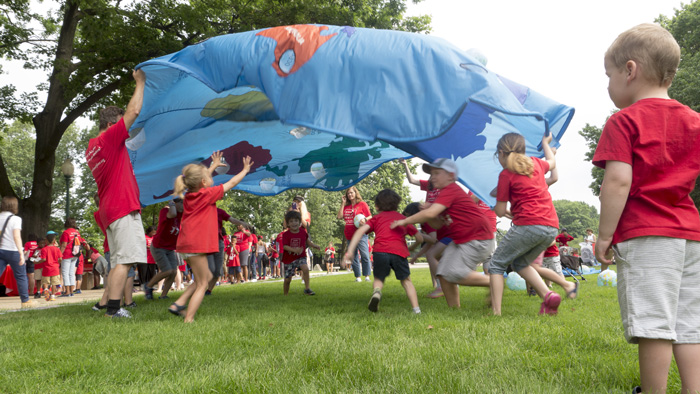 Kids play with parachute at Moms Clean Air Force Play-In for Climate Action
