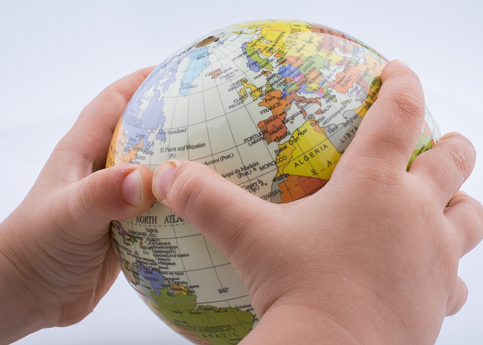Baby's hands holding toy globe