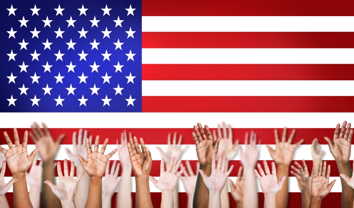 Raised hands in front of US flag