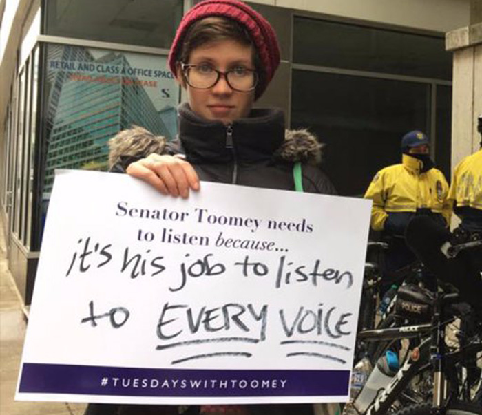 Activist holding tuesdays with toomey sign asking for him to listen to his constituents
