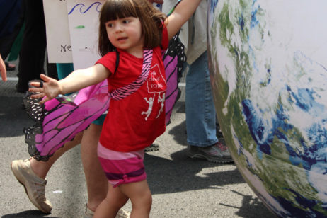 little girl in butterfly outfit at climate march