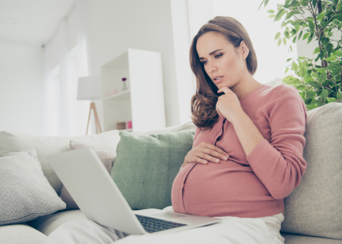 pregnant woman reading media on computer