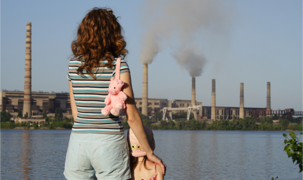 Mother and child look at polluting industry that is being given priority by the Trump EPA