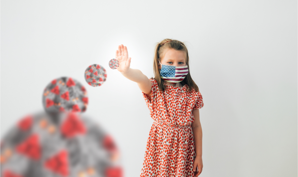 girl wearing cloth mask holding up hand against images of covid molecules