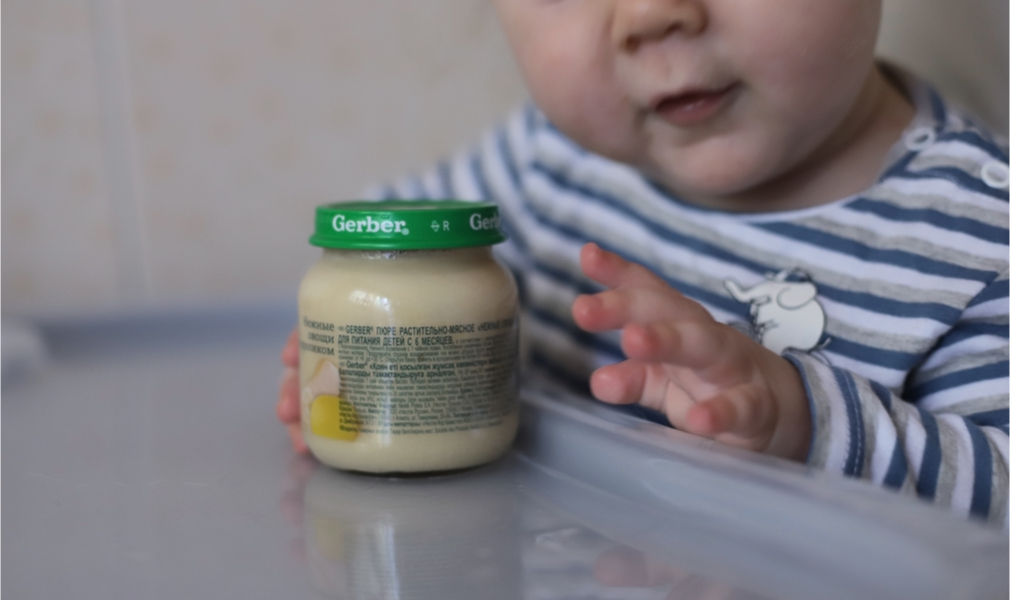 Child with jar of Gerber baby food