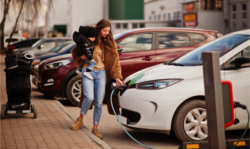 Woman and child at electric vehicles charging shation