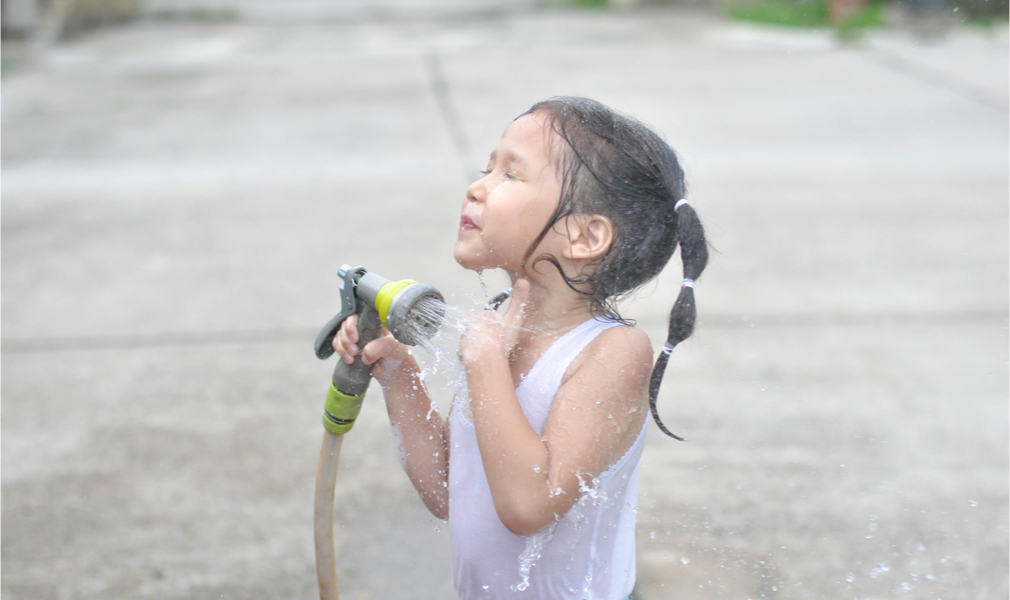 Little girl cools off with water during dangerous heat