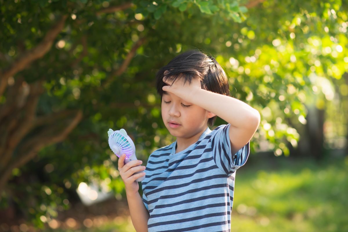child using a fan, one way to combat a heat dome