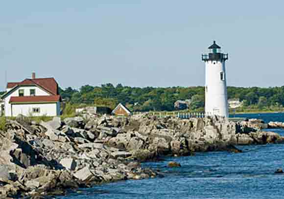 New England town waterfront with house and lighthouse surrounded by clean air