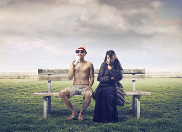 photo depicting extreme weather; a man sits on a bench in a swimsuit, and a woman is bundled in a coat