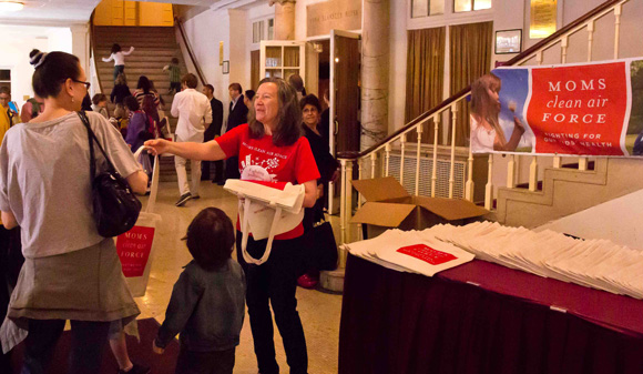 Photo of MCAF senior director Dominique Browning handing out tote bags at the Raffi concert