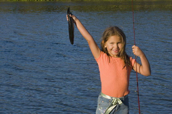 Little girl holding up a fish she caught
