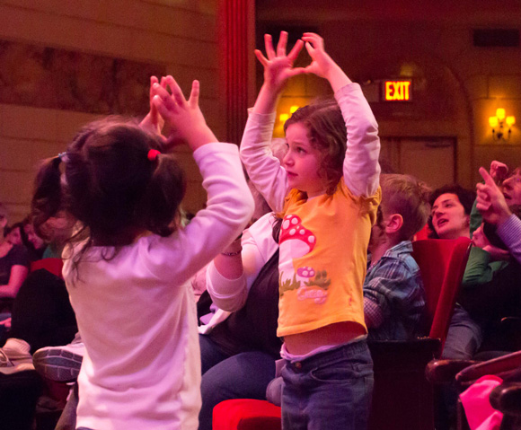 Two small girls dancing at the Raffi concert
