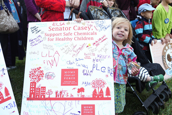 Young MCAF member holds sign at stroller brigade event