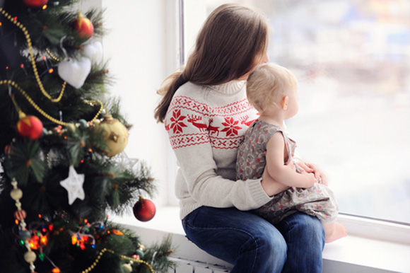 Mother and child near Christmas tree look out over the Great Lakes