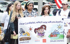 People at the rally hold sign of MCAF billboard