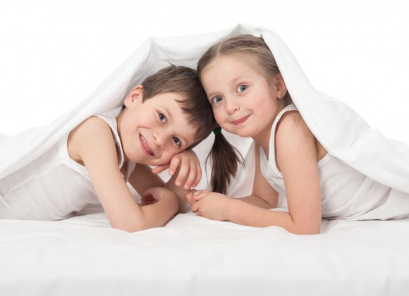 a boy and a girl hiding under a sheet
