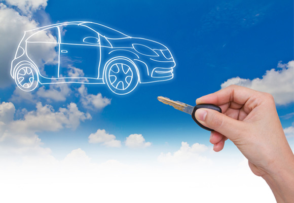 Blue sky and clouds with cloud outline of a car and hand holding car key