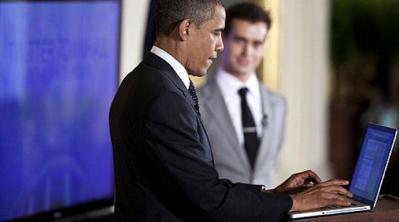 President Barack Obama tweeting on a laptop computer