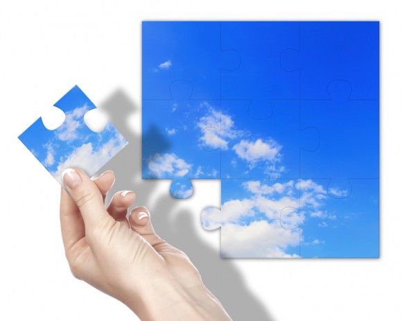 Blue sky puzzle with one piece being held out.