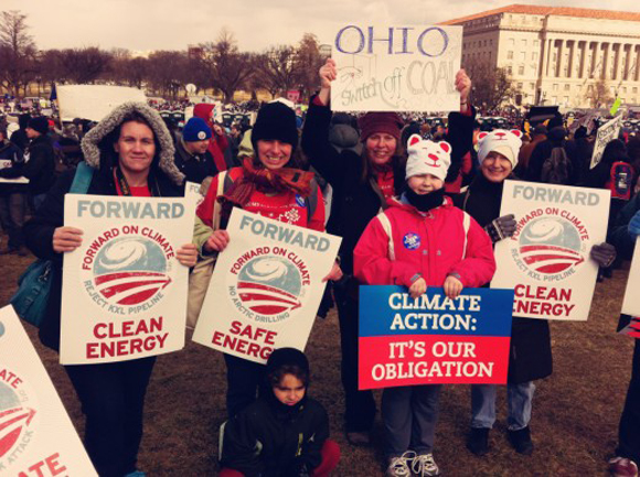 Activists holding up signs at the DC climate rally