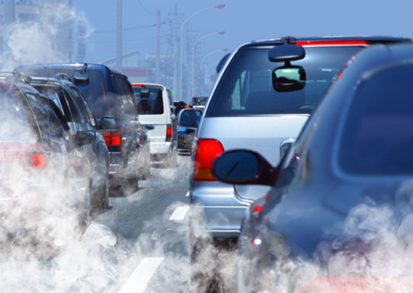 Cars in traffic with soot pollution coming from tailpipes